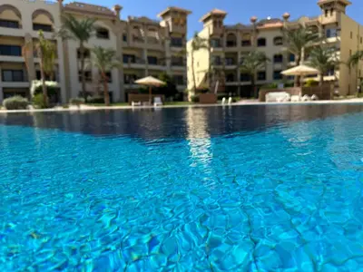 a large swimming pool in front of a building at Fully equipped studio Sahl Hasheesh in Hurghada