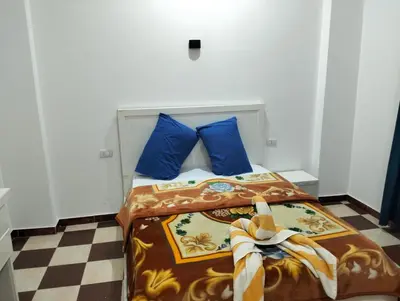 a bedroom with a bed with blue pillows at Djorff Guest House in Luxor