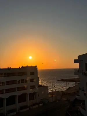 a sunset over the ocean and a building at Hurghada seaview apartment in Hurghada