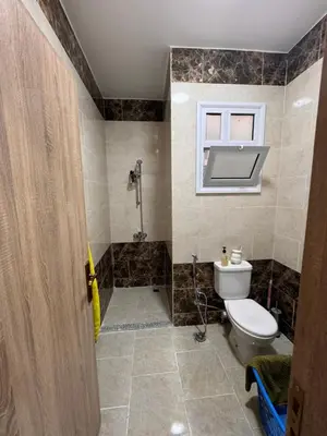 a bathroom with a toilet and a shower and a window at Hurghada seaview apartment in Hurghada