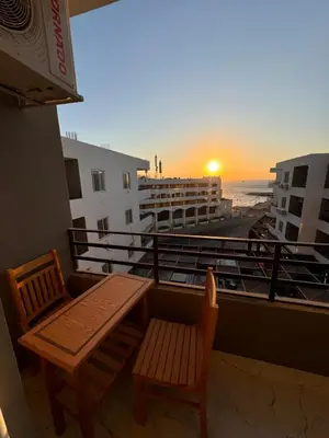 a balcony with a bench and a view of the beach at Cosy Hurghada Apartments in Hurghada