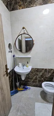 a bathroom with a sink and a mirror and a toilet at Cosy Hurghada Apartments in Hurghada