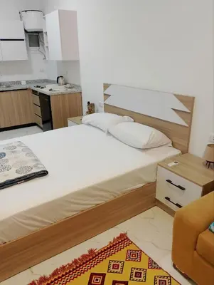 a bedroom with a large bed and a kitchen at Cosy Hurghada Apartments in Hurghada