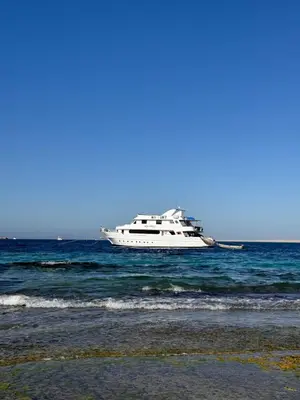 a boat floating in the ocean near a beach at Cosy Hurghada Apartments in Hurghada