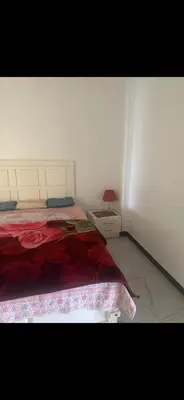 a bedroom with a bed with a red comforter at King mou in ‘Ezbet Abu Ḥabashi
