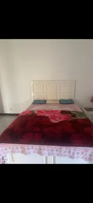 a white bed with a red blanket on top of it at King mou in ‘Ezbet Abu Ḥabashi