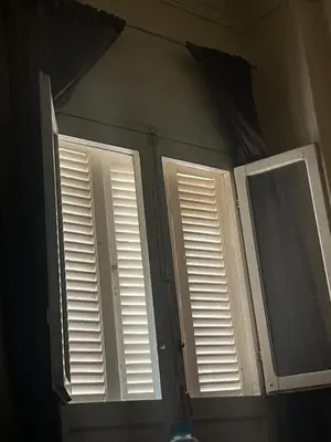 two shuttered windows in a bathroom with a mirror at LXR Oasis in Luxor