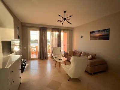 a living room with a couch and a table and chairs at The Sunset Heaven - 2 bedrooms - Golf Steigenberger, El Gouna in Hurghada