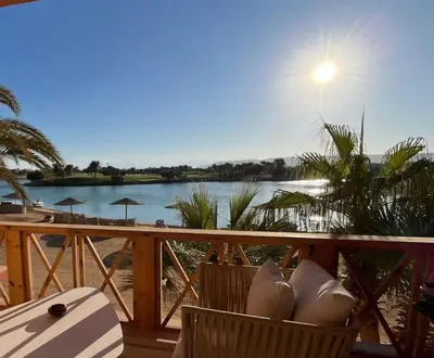 a balcony with a view of a river and the sun at The Sunset Heaven - 2 bedrooms - Golf Steigenberger, El Gouna in Hurghada