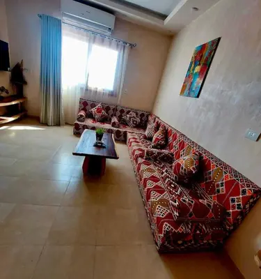 a living room with a couch and a table at Komfortowy apartament na dachu w sercu miasta in Hurghada