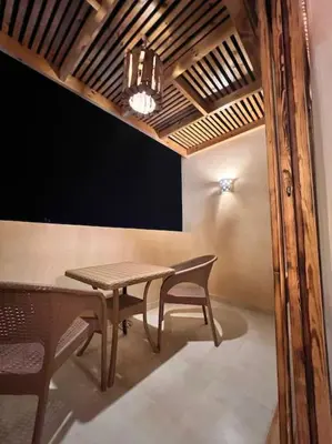 a table and chairs in a room with a chandelier at Komfortowy apartament na dachu w sercu miasta in Hurghada