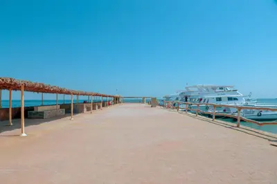 a dock with a boat docked next to the water at Aladdin Beach Resort in Hurghada