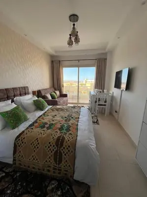 a bedroom with a large bed and a living room at Chic Studio with Modern Comforts in Hurghada