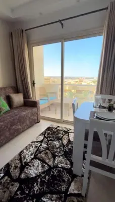 a living room with a couch and a table and a window at Chic Studio with Modern Comforts in Hurghada