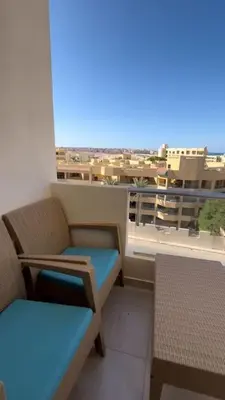 a balcony with a bench and a view of a city at Chic Studio with Modern Comforts in Hurghada