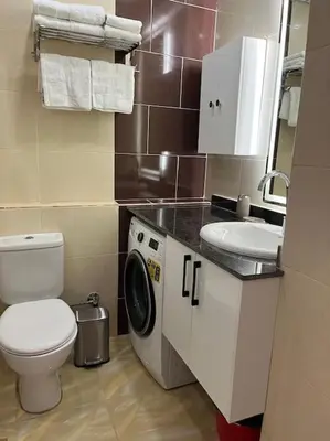 a bathroom with a toilet sink and a washing machine at Chic Studio with Modern Comforts in Hurghada