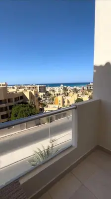 a balcony with a window with a view of a city at Chic Studio with Modern Comforts in Hurghada