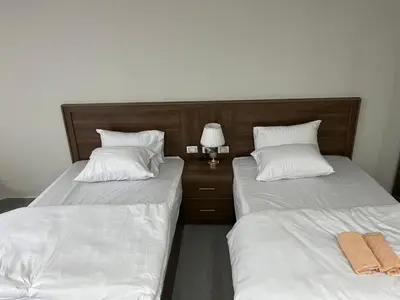 two beds with white sheets and a lamp in a room at Scandic sea view in Hurghada