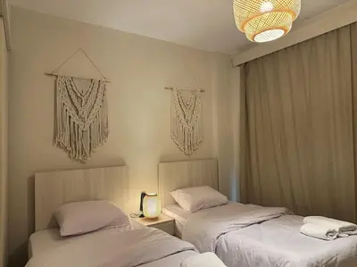 a bedroom with two beds and a chandelier at Chic 3BR Ground Free Beach & Pool access at Mangroovy in Hurghada