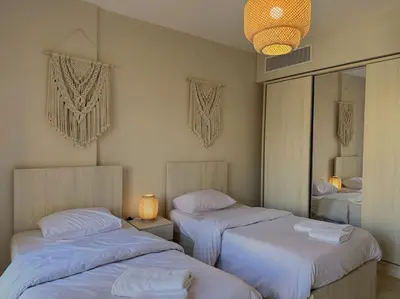 a bedroom with two beds and a room with a mirror at Chic 3BR Ground Free Beach & Pool access at Mangroovy in Hurghada