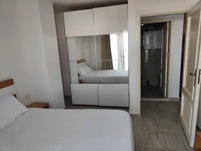 a white bedroom with a bed and a mirror at Stunning Rooftop 1 Bed Apartment in Hurghada