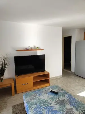 a living room with a flat screen tv on a entertainment center at Stunning Rooftop 1 Bed Apartment in Hurghada