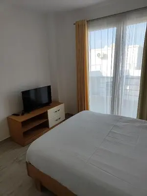 a bedroom with a bed and a tv and a window at Stunning Rooftop 1 Bed Apartment in Hurghada