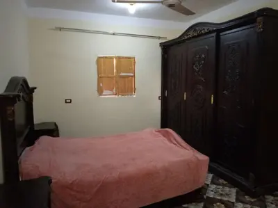 a bedroom with a bed and a wooden cabinet at SaYeD guest house in Dâbûb