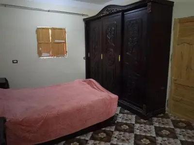 a bedroom with a bed and a large wooden cabinet at SaYeD guest house in Dâbûb