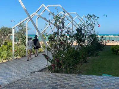 two women walking down a walkway in a garden at Fanadir bay resort in Hurghada
