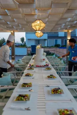 a long table with a wedding cake and plates of food at Fanadir bay resort in Hurghada