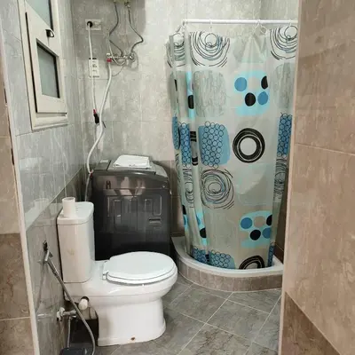 a bathroom with a toilet and a shower curtain at Almina Apartments - Come and relax with us in style in Hurghada