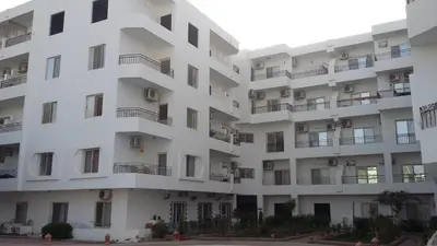 an external view of a white apartment building at Almina Apartments - Come and relax with us in style in Hurghada