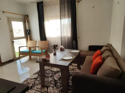 a living room with a couch and a table at Almina Apartments - Come and relax with us in style in Hurghada