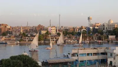 a group of sailboats on a river in a city at elephantine nile view house in Aswan