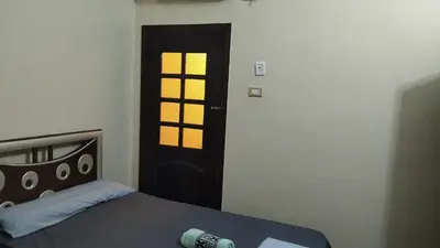 a bedroom with a bed and a door with a window at elephantine nile view house in Aswan
