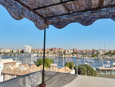 a view of a harbor from a balcony with an umbrella at elephantine nile view house in Aswan