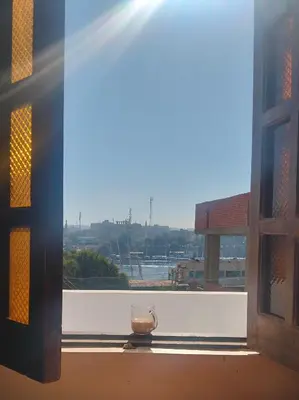 a glass jar sitting on a window sill with the sunlight at elephantine nile view house in Aswan