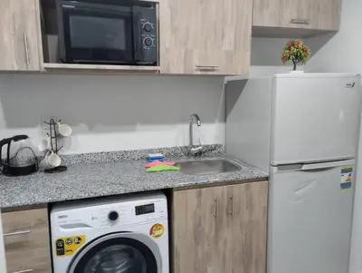 a kitchen with a washing machine and a microwave at scandic in Hurghada