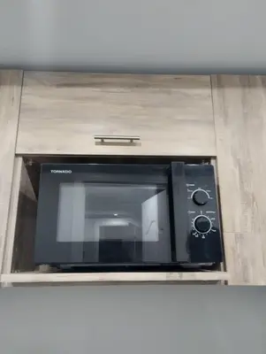 a microwave oven in a cabinet in a kitchen at scandic in Hurghada