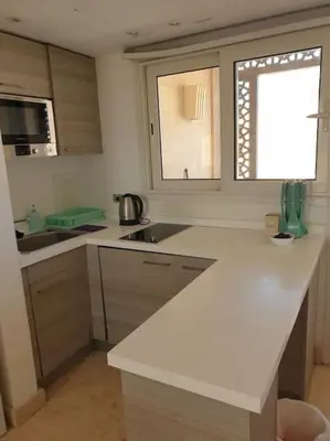 a kitchen with a white counter and a window at Serene Pool View 8Mins to Marina in Hurghada