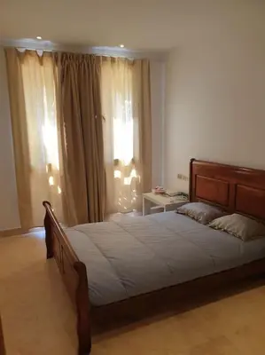 a bedroom with a large bed in front of a window at Serene Pool View 8Mins to Marina in Hurghada