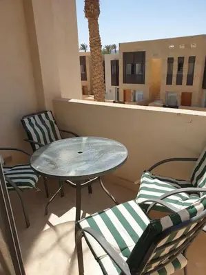 a patio with a table and chairs on a balcony at Serene Pool View 8Mins to Marina in Hurghada