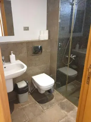 a bathroom with a shower and a toilet and a sink at Serene Pool View 8Mins to Marina in Hurghada
