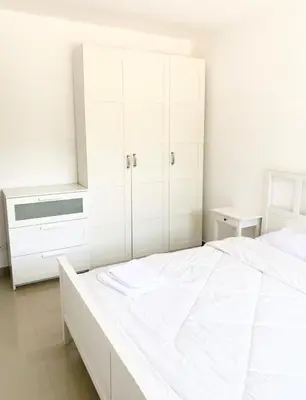 a white bedroom with a large bed and white cabinets at El Gouna -G-cribs B6 in El Gouna