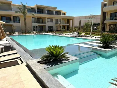 a large swimming pool with chairs and a building at El Gouna -G-cribs B6 in El Gouna