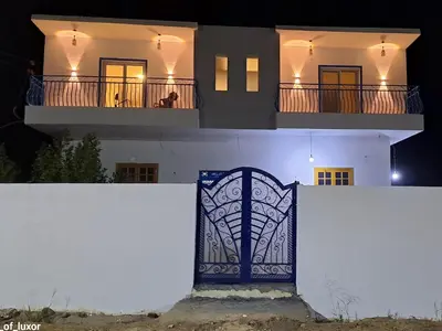 a white house with a gate in front of it at Al Hayat house in Luxor