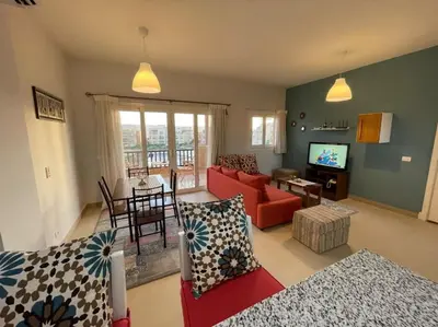 a living room with a red couch and a table at Luxury Stays in Waterside El Gouna in Hurghada