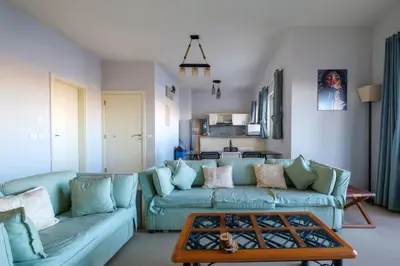 a living room with a blue couch and a table at Luxury Stays in Waterside El Gouna in Hurghada