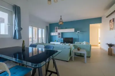 a blue living room with a couch and a table at Luxury Stays in Waterside El Gouna in Hurghada